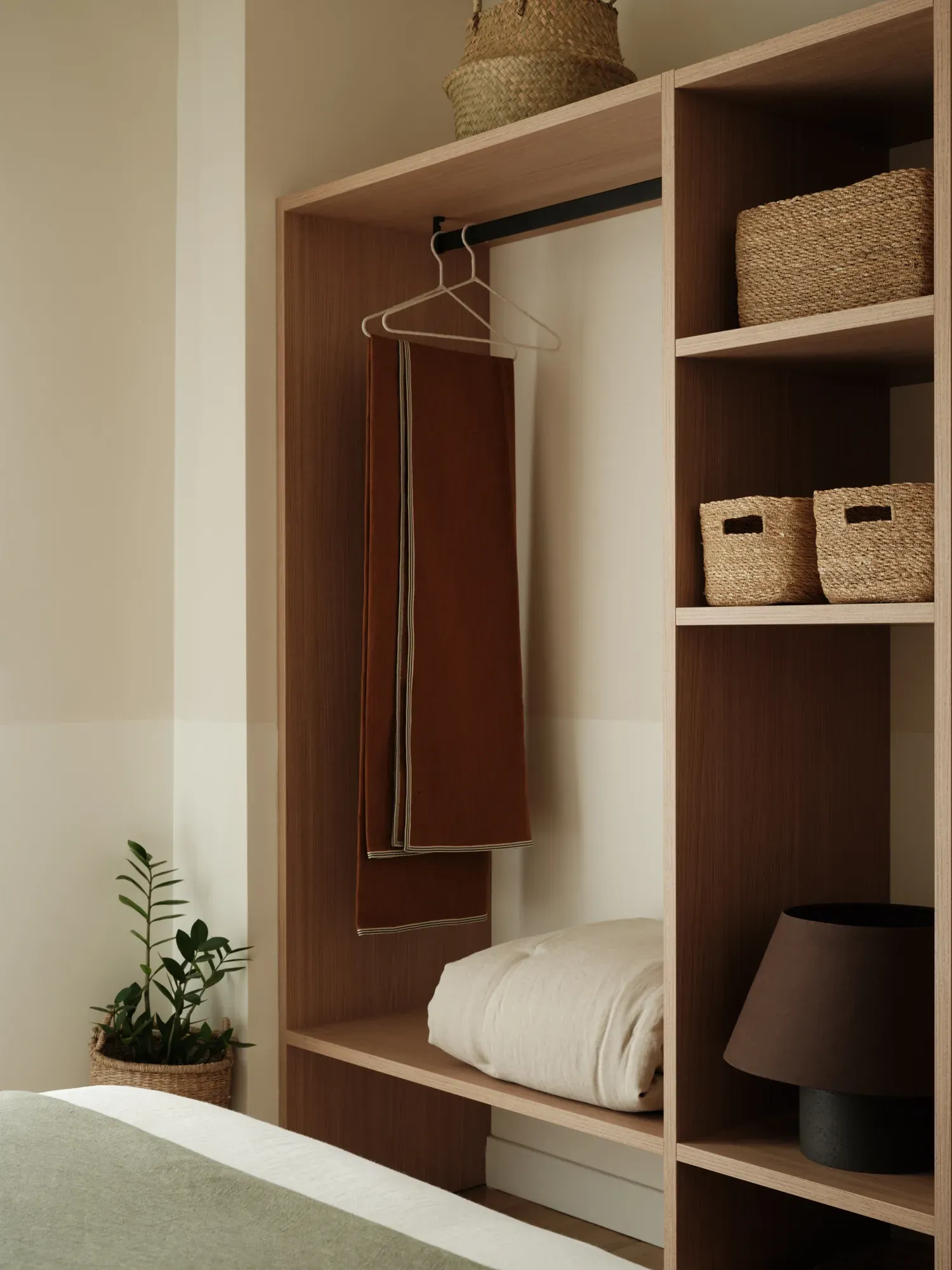 Open timber wardrobe with hanging rail and woven storage baskets